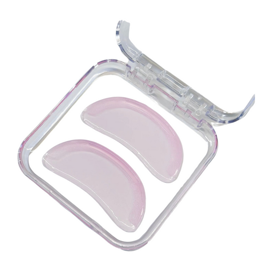 Two translucent pink curved silicone nasal pads inside a clear plastic storage case, shown on a plain white background.