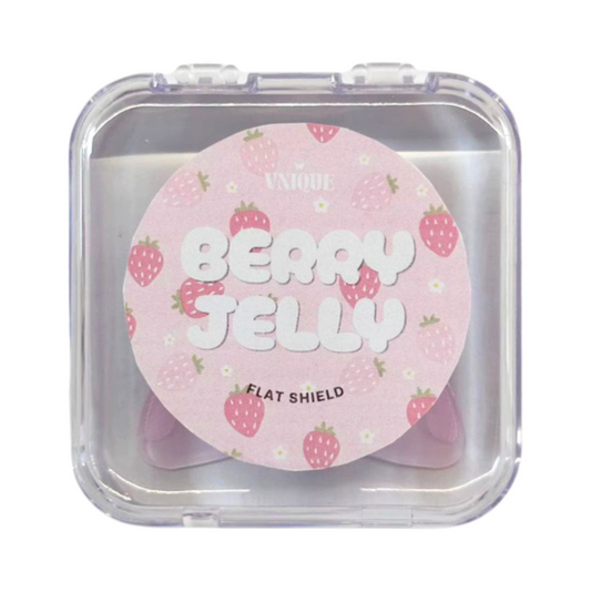 A round pink cosmetic flat shield compact with strawberry illustrations, labeled 'UNIQUE BERRY JELLY FLAT SHIELD,' shown inside a clear plastic square case on a white background.